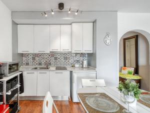 uma cozinha branca com armários brancos e uma mesa em Apartment SANTA MARIA by Interhome em Roses