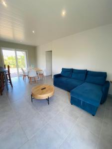uma sala de estar com um sofá azul e uma mesa em Villa cosy Blue Lagon em Rivière-Salée