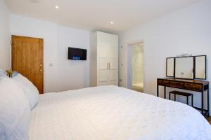 een witte slaapkamer met een groot bed en een spiegel bij Stunning Newly Fully Furnished Bedroom Ensuite - Room 2 in Brentwood