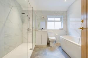 uma casa de banho com uma banheira, um WC e um lavatório. em Stunning Newly Fully Furnished Bedroom Ensuite - Room 2 em Brentwood