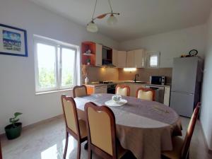 a kitchen with a table and chairs in a room at Apartment Ani in Slano