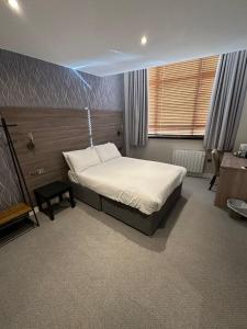 um quarto com uma cama e uma secretária. em Hatfield Lodge em Lowestoft