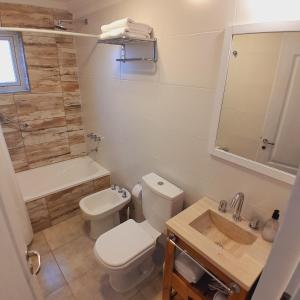 a bathroom with a toilet and a sink at Los Coirones Aparts - El Chaltén - Patagonia in El Chalten