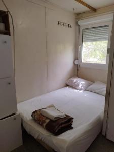 a small bedroom with a white bed with a window at Hostel Marina in Sutomore