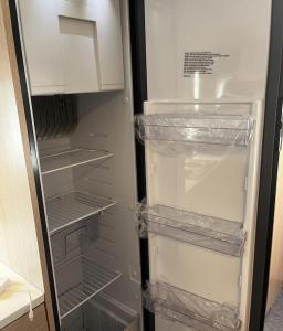 an empty refrigerator with its door open with its shelves at Hilazon Caravan in Ashdod