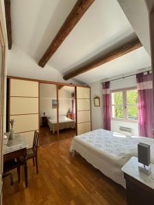 um quarto com 2 camas, uma secretária e uma janela em La Boissetane, maison provençale avec piscine et jardin, au pied du Luberon em Saint-Martin-de-Castillon