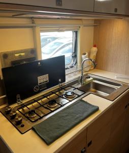 a kitchen with a stove and a sink at Hilazon Caravan in Ashdod