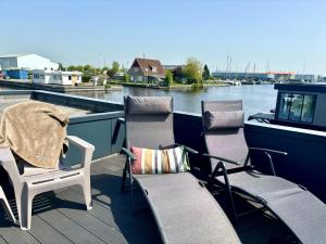 um par de cadeiras sentadas no convés de um barco em Holiday Home Harboursuite incl- boot-1 by Interhome em Woudsend