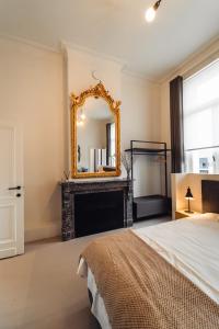 een slaapkamer met een open haard en een spiegel bij Luxeverblijf B&B het Wevershuis in Herentals