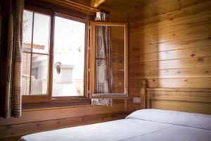 Schlafzimmer mit einem Bett und einem Fenster in der Unterkunft Aranjuez Camping & Bungalows in Aranjuez