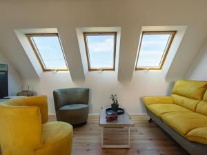 een woonkamer met gele meubels en ramen bij Holiday Home Ty Mat by Interhome in Guimaëc