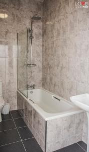 een badkamer met een bad, een wastafel en een toilet bij Keppels Head Hotel in Portsmouth