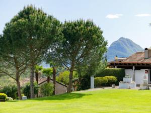 a house with two trees in a yard at Apartment Villaggio Sureggio - App- C1 by Interhome in Lugaggia