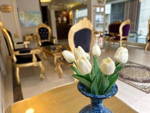 un vaso blu con fiori bianchi su un tavolo di napolyon hotel a Istanbul