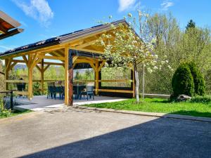 een houten paviljoen met een tafel en stoelen in een tuin bij Holiday Home Gorski Hedon by Interhome in Čabar