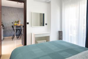 a bedroom with a bed and a table and a mirror at Valeria Apartament Cozy & Quiet in Kallithea Halkidikis