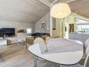 a living room with a white table and a kitchen at Holiday Home Ubbe - 800m from the sea in Western Jutland by Interhome in Fanø