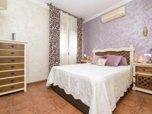 een slaapkamer met een wit bed en paarse muren bij Holiday Home Vereda Cádiz Conil by Interhome in Chiclana de la Frontera