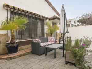 een patio met een stoel, een parasol en planten bij Holiday Home Vereda Cádiz Conil by Interhome in Chiclana de la Frontera