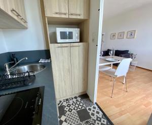 Una pequeña cocina con fregadero y microondas. en Superbe appartement confortable, proche centre ville, en Rennes 18 fotos más
