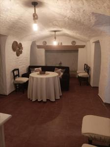 ein Wohnzimmer mit einem Tisch und einem Sofa in der Unterkunft Cueva la Trapera in Benamaurel