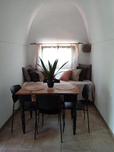 a dining room with a table and a couch at Dammuso Libeccio in Pantelleria