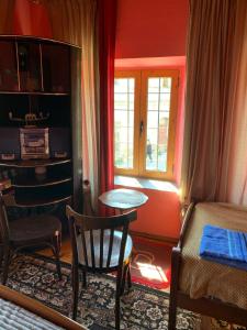 um quarto com uma cama, uma mesa e uma janela em Rooms for Rent em Shkodër