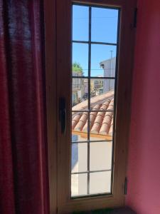 a window with a view of a roof at Rooms for Rent in Shkodër