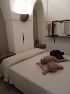 a bedroom with a white bed with a towel on it at Dammuso Libeccio in Pantelleria