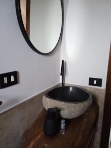 a bathroom with a stone sink and a mirror at Dammuso Libeccio in Pantelleria