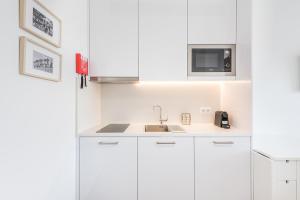 a white kitchen with a sink and a microwave at GuestReady - Port Studio 2 in Bandeira