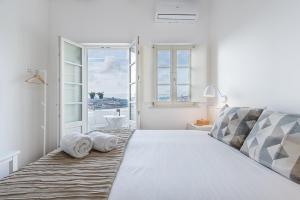 a white bedroom with a large bed with towels on it at GuestReady - Port Studio 2 in Bandeira +17 photos