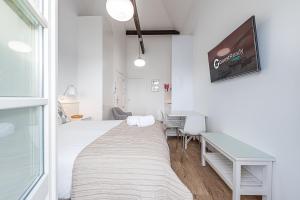 a bedroom with a bed and a desk and a tv at GuestReady - Port Studio 2 in Bandeira