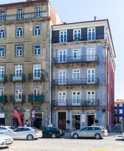 un grand bâtiment avec des voitures garées devant lui dans l'établissement GuestReady - Ribeira Apt in Porto center, à Porto