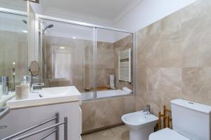 La salle de bains est pourvue de toilettes, d'un lavabo et d'une douche. dans l'établissement GuestReady - Ribeira Apt in Porto center, à Porto