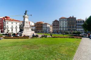 Une statue au milieu d'un parc avec des bâtiments dans l'établissement GuestReady - Ribeira Apt in Porto center, à Porto