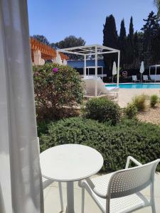 uma mesa branca e cadeiras ao lado de uma piscina em Sol i Vida Hotel - Adults Only em Porto Cristo