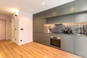 a kitchen with gray cabinets and a wooden floor at GuestReady - Stylish studio in Gaia in Vila Nova de Gaia