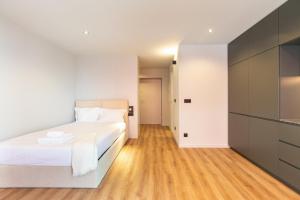 a bedroom with a white bed and a kitchen at GuestReady - Stylish studio in Gaia in Vila Nova de Gaia +18 photos