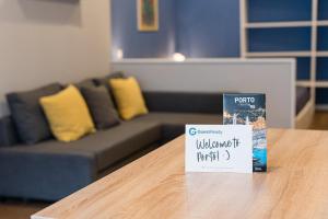 ein Schild auf einem Tisch in einem Wohnzimmer mit Sofa in der Unterkunft GuestReady - The New Lazuli Flat in Porto