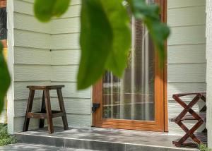 uma porta de madeira de uma casa com um banco em Cottage Retreat DALAT em Da Lat