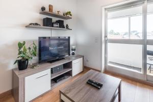 ein Wohnzimmer mit einem TV und einem Couchtisch in der Unterkunft GuestReady - Never Say Never in Porto