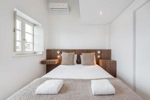 - une chambre blanche avec un lit et deux oreillers dans l'établissement GuestReady - Riverview Douro Terrace, à Vila Nova de Gaia