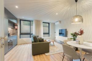 a kitchen and living room with a table and a dining room at GuestReady - Khaki Roof in Santo Ovídio