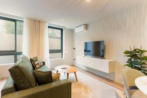 a living room with a couch and a tv at GuestReady - Khaki Roof in Santo Ovídio +18 photos