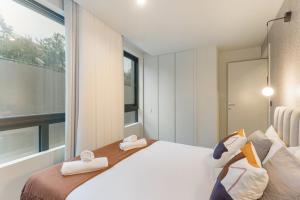 a bedroom with a large bed and a large window at GuestReady - Khaki Roof in Santo Ovídio