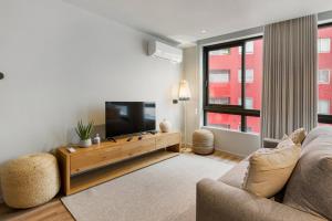a living room with a couch and a flat screen tv at GuestReady - Grey Roof in Vila Nova de Gaia in Santo Ovídio +17 photos