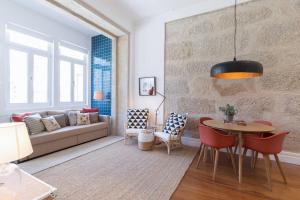a living room with a couch and a table and chairs at GuestReady - Splendid Freitas Apartment w/ Patio in Porto