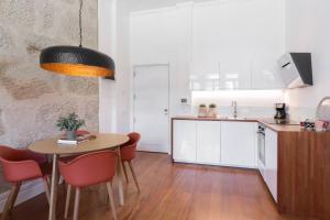 a kitchen and dining room with a table and chairs at GuestReady - Splendid Freitas Apartment w/ Patio in Porto