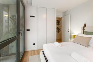 a bedroom with a white bed and a glass wall at GuestReady - Grey Roof in Vila Nova de Gaia in Santo Ovídio